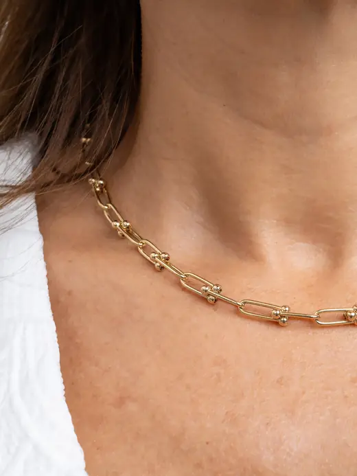 Detalle del collar de eslabones dorados